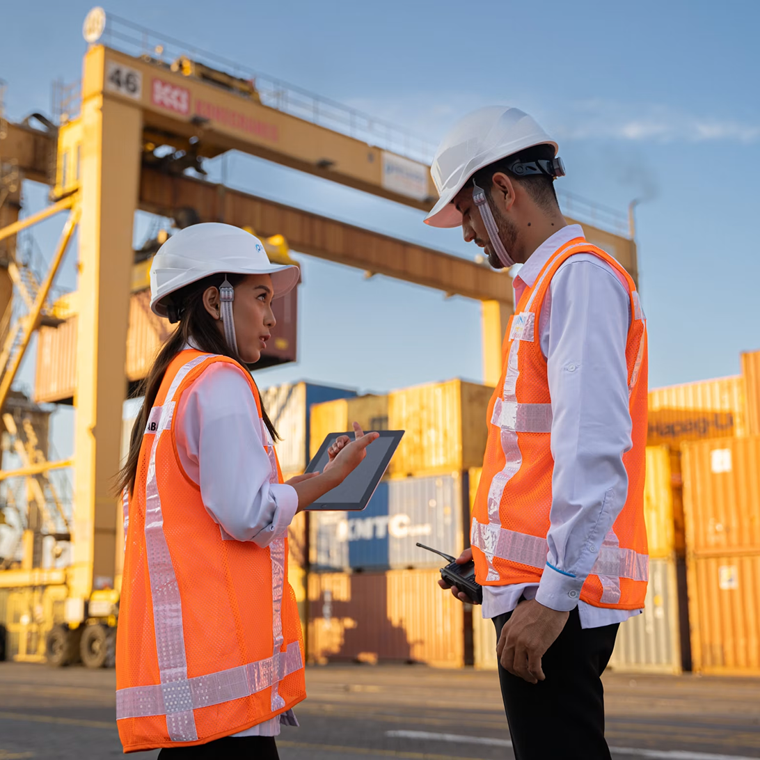 Dos trabajadores revisando datos de prevención en un puerto